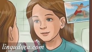 A girl with loose hair is looking at herself in the mirror. Near the right edge of the mirror there is a postcard depicting a man in the middle of a jump.